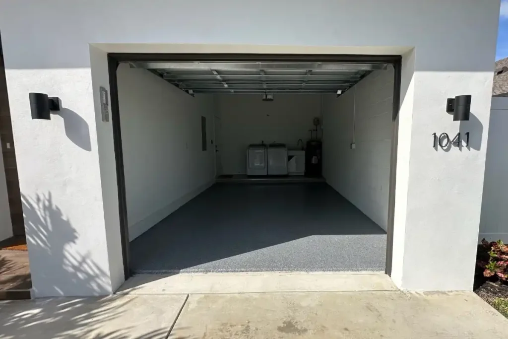 Epoxy garage floor coating in a Boston garage showing gloss finish at the door in winter